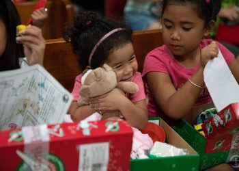 A girl in Saipan tenderly hugs the teddy bear she found in her shoebox gift.  (Photo is courtesy of Samaritan’s Purse)