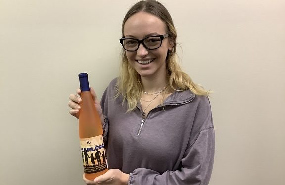 Big Brothers Big Sisters of Jefferson, Elk, and McKean Counties Case Manager, Lacy Reed displays a bottle of Wilcox Winery’s new wine, “Fearless.”  (Provided photo)