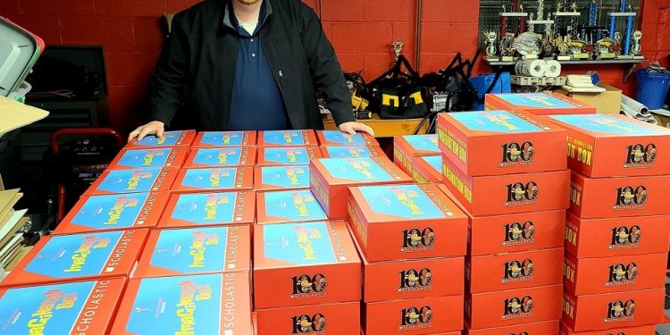 Matt Reed of First Class Children’s Foundation poses in his garage with over 300 “Imagination Boxes” full of school supplies and books for students that the group distributed at the C. G. Johnson Elementary School in Reynoldsville last month.