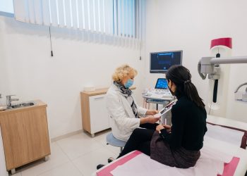Doctor and patient with protective face masks during the medical examination
