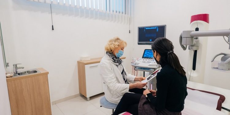 Doctor and patient with protective face masks during the medical examination