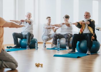 Group of senior people exercising on balls together in a gym