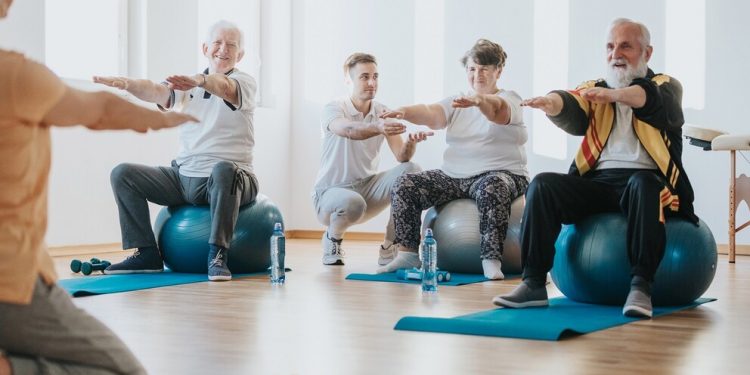 Group of senior people exercising on balls together in a gym