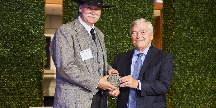 Rawland Cogan accepts his Alumni Fellow award from Penn State President Eric Barron.