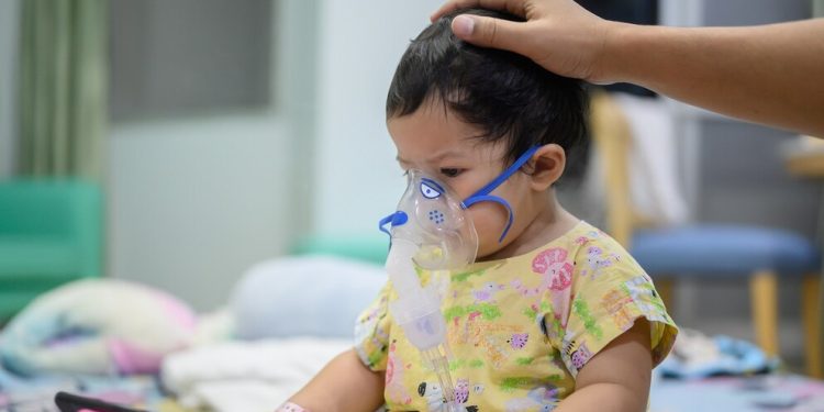 Asian baby was sick as Respiratory Syncytial Virus (RSV) in kid hospital. Thai little girl having inhaler containing medicine for stop coughing and disease flu.