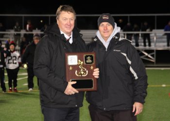 Bison head coach Tim Janocko alongside athletic director Bob Gearhart with the District IX championship plaque.