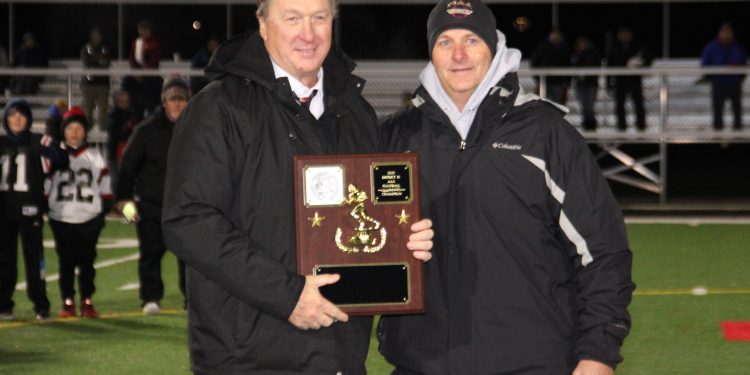 Bison head coach Tim Janocko alongside athletic director Bob Gearhart with the District IX championship plaque.