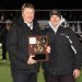 Bison head coach Tim Janocko alongside athletic director Bob Gearhart with the District IX championship plaque.