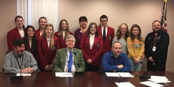 In front, from left, are Commissioners Tony Scotto, John A. Sobel, board chairman, and Dave Glass. In the second row are: students Chloe Rowles, Karly Framer and Raven Myers. In the third row are: students Makenzie Hullihen, Lydia Swatsworth, Savanna Anderson, REST Inc. Board President Julie Fenton, student William Rainey, and REST Inc. Board Member Susie Albert with her granddaughter, Lauren Phillips. (Photo by GANT News Editor Jessica Shirey)