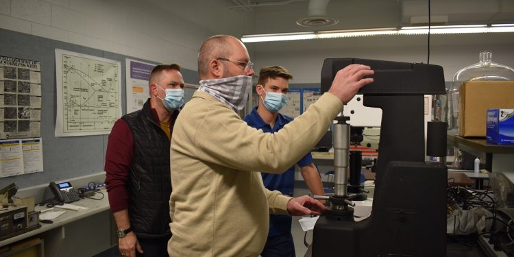 In the photo: In front, Penn State DuBois engineering student Scot Coble tests the hardness of a powder metal sample produced through the Vulcan Process. In back, left to right, senior adjunct faculty member Stephen Feldbauer and Penn State Material Sciences and Engineering student Jacob Feldbauer await the results.