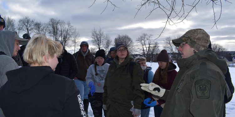 Pennsylvania State Game Warden Thomas Henry, at far right, led Penn State DuBois Wildlife Technology students in a simulated investigation of the illegal killing of a deer.  For student Laurie Enders, center, the exercise offered a glimpse into the career she plans to enter after graduation.