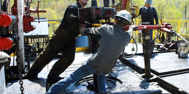 In this April 23, 2010, file photo, workers move a section of well casing into place at a Chesapeake Energy natural gas well site near Burlington, Pa., in Bradford County.  Ralph Wilson/AP Photo