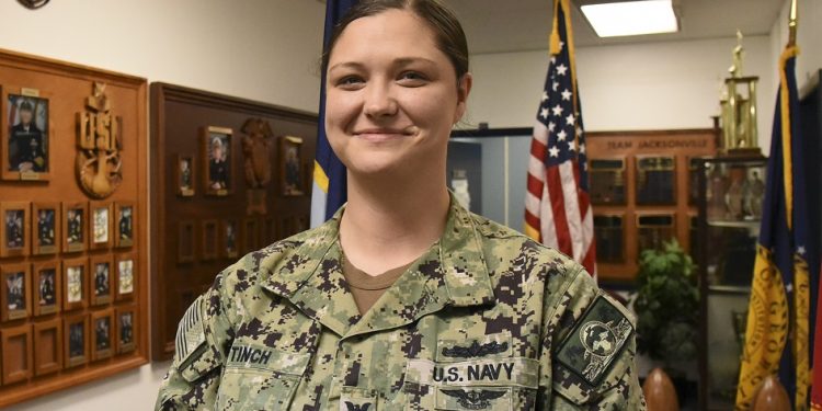 220215-N-WP-400-003 Jacksonville, Fla. (February 15, 2022) Navy Counselor (Recruiter) 1st Class Emma Tinch, from Penfield, Pennsylvania assigned to Navy Talent Acquisition Group Jacksonville, poses for a photo as recruiter in the spotlight. Navy Talent Acquisition Group Jacksonvilles are of responsibility includes more than 30 Navy Recruiting Station and Navy Officer Recruiting Stations spread over 144,000 square miles of Florida and Georgia (U.S. Navy photo by Mass Communication Specialist 1st Class Sean Stafford/Released)