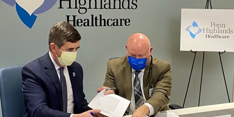 John McKeegan, president of Mount Aloysius College, (l.) and John Sutika, president of Penn Highlands DuBois, sign the agreement to partner on a Surgical Tech program. The program will provide incoming Mount Aloysius College students with up to $44,000 in educational funding, hiring incentives and guaranteed employment at any Penn Highlands Healthcare hospital.