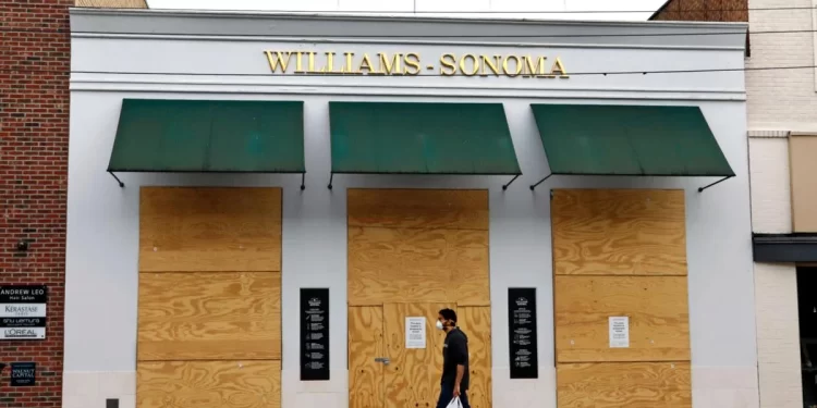 A man walks April 29, 2020, in the Shadyside shopping district of Pittsburgh past a temporarily boarded up Williams-Sonoma store.

Gene J. Puskar / AP photo