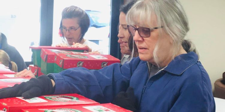 Jane Davis, Prayer Team coordinator, prays over shoebox gifts during 2021 National Collection Week at West Central PA’s Central Drop-off in Curwensville.