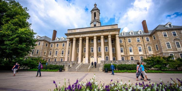 Students and adults walk in front of the Old Main building on the campus of Penn State University, in State College, Pa.

Kristopher Kettner | Shutterstock.com