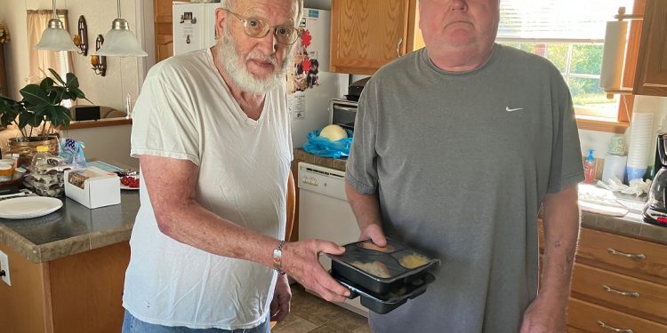 Meals on Wheels consumer James Davis, left, receives meals from delivery driver Bob Rubly at his home in Sanborn, Clearfield County.