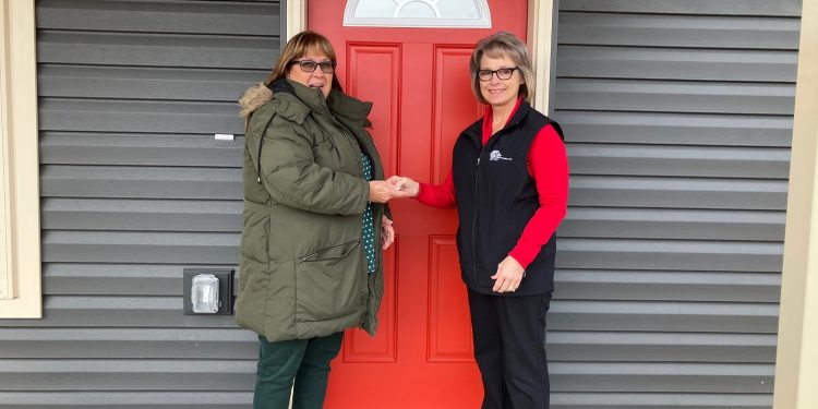 Donna Shaw, left, receives the keys to her new home at Village of Hope from Mature Resources CCAAA CEO Kathleen Gillespie. Shaw is the first person to officially become a resident at the VOH following the recent completion of the first homes at the site.