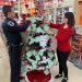 Clearfield Borough Assistant Police Chief Nathan Curry, and CCAAA Fundraising and Events Specialist Ronda Vaughn hang tags from a Giving Tree at the Family Dollar store in Clearfield. Curry and Vaughn head up the project for their respective agencies each year.