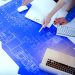 Two individuals reading and marking up a blueprint drawing.

Credit: Adobe Stock