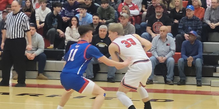 Cole Miller (33) tries to find a lane to pass the ball as Blaise Krizner (11) plays tight defense.  Miller finished with 13 points in the loss to the Mustangs.