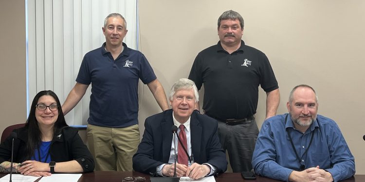 Pictured, in front from left, are Commissioners Mary Tatum, John Sobel and Dave Glass. In the back are Jeremy Ruffner, 911 coordinator, and Dave McClure, Emergency Management Director. (Photo by GANT News Editor Jessica Shirey)