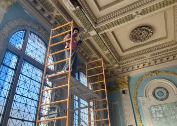 Rob Wozniak from Preservation Works of Easton, Pa., inspects original plasterwork in the coffee shop space at the Dimeling Hotel.