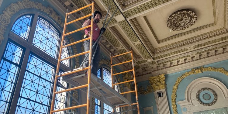 Rob Wozniak from Preservation Works of Easton, Pa., inspects original plasterwork in the coffee shop space at the Dimeling Hotel.