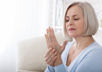 Woman massaging her arthritic hand and wrist closeup