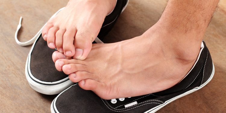 Man scratching his athlete's foot.Close up.