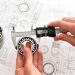 A quality engineer measuring a ball bearing with calipers to ensure its compliance, with a reference diagram in the background.

Credit: Adobe Stock