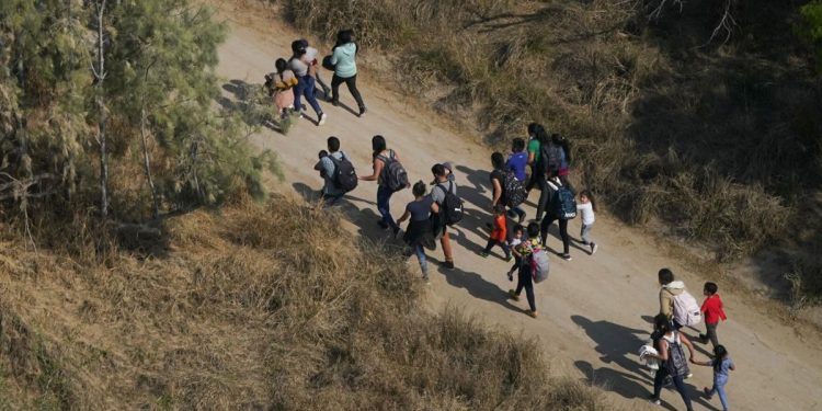 Migrants walk on a dirt road after crossing the U.S.-Mexico border, Tuesday, March 23, 2021, in Mission, Texas.

Julio Cortez / AP Photo