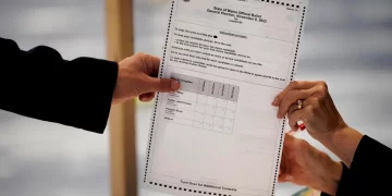 A ballot showing the choices for Maine's 2nd Congressional District is handed to a voter, Tuesday, Nov. 8, 2022, in Lewiston, Maine. The state's ranked choice voting system will likely be used to determine the winner in a close race between incumbent Democrat Jared Golden and Republican Bruce Poliquin.

Robert F. Bukaty | AP