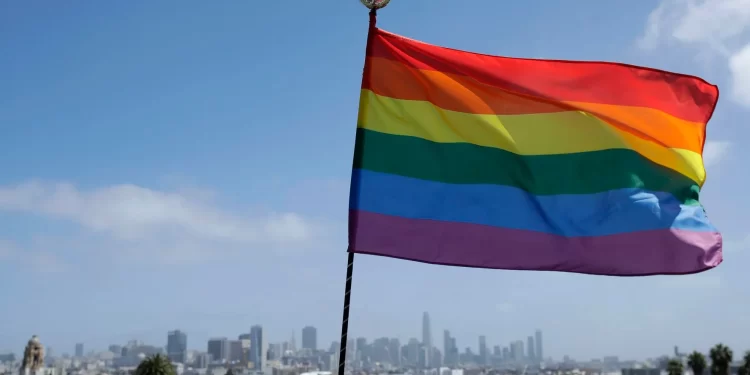 A rainbow flag set up by Ronnie Alvarez, lead designer of Balloon Magic, flies over the skyline at Dolores Park in San Francisco, Sunday, June 28, 2020. (AP Photo/Jeff Chiu)
