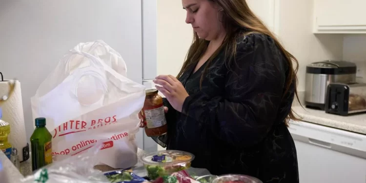 Jaqueline Benitez puts away groceries at her home in Bellflower, Calif., on Monday, Feb. 13, 2023. Benitez, 21, who works as a preschool teacher, depends on California's SNAP benefits to help pay for food.

AP Photo/Allison Dinner