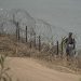 Migrant walks along concertina wire past a guardsman after crossing the Rio Grande from Mexico near the site where large buoys are being deployed to be used as a border barrier in Eagle Pass, Texas, Wednesday, July 12, 2023.

Eric Gay | AP Photo