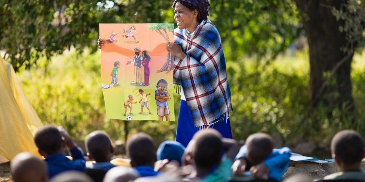 Children sit at attention while a ministry partner shares the Gospel at an outreach event in Botswana. (Photo is courtesy of Samaritan’s Purse)