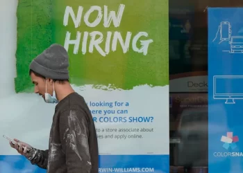 A man walks past a 'Now Hiring' sign on a window at Sherwin Williams store in Woodmere Village, Ohio. 

Tony Dejak | AP Photo