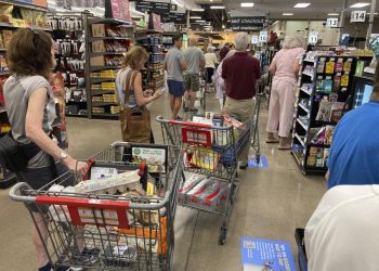 In this Thursday, Aug. 25, 2022, photograph, shoppers queue up in long lines to check out of a King Soopers grocery store in southeast Denver. 

AP Photo/David Zalubowski