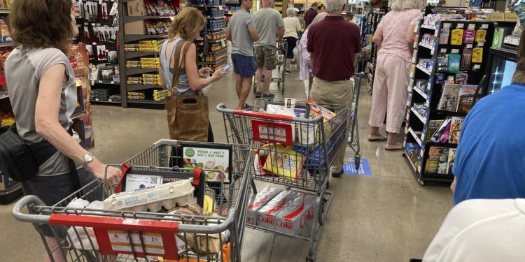 In this Thursday, Aug. 25, 2022, photograph, shoppers queue up in long lines to check out of a King Soopers grocery store in southeast Denver. 

AP Photo/David Zalubowski