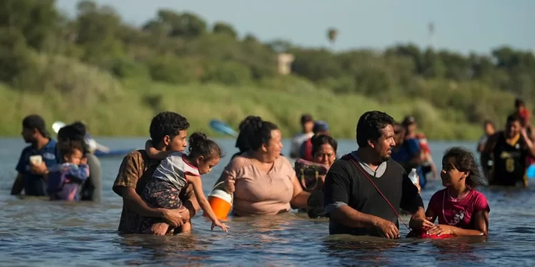 Migrants navigate around concertina wire along the banks of the Rio Grande after crossing from Mexico into the U.S., Tuesday, Aug. 1, 2023, in Eagle Pass, Texas. Concertina wire and newly place buoys being used as a floating barrier, are making in more difficult and dangerous to cross the Rio Grande. 

Eric Gay | AP