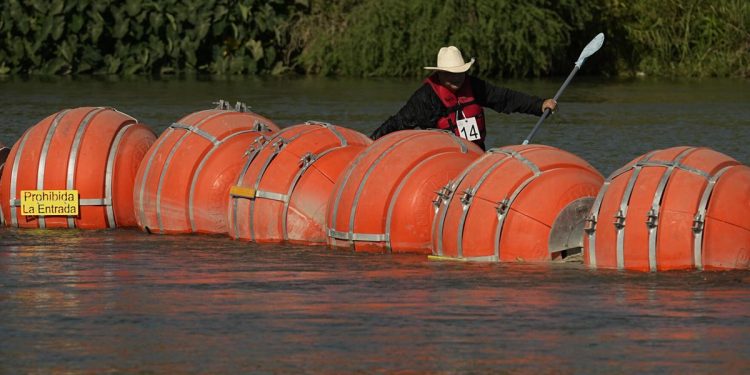 A kayaker passes large buoys being used as a floating border barrier on the Rio Grande Tuesday, Aug. 1, 2023, in Eagle Pass, Texas.

Eric Gay | AP