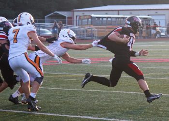 Carter Chamberlain (45) continues to gain yardage despite a Tyrone defender pulling on his jersey.