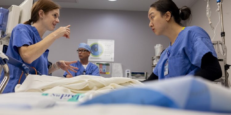 Dr. Jill McLelland, left, signs to Edith Dong while they perform a sedated auditory brainstem response evaluation to estimate hearing sensitivity on a patient.