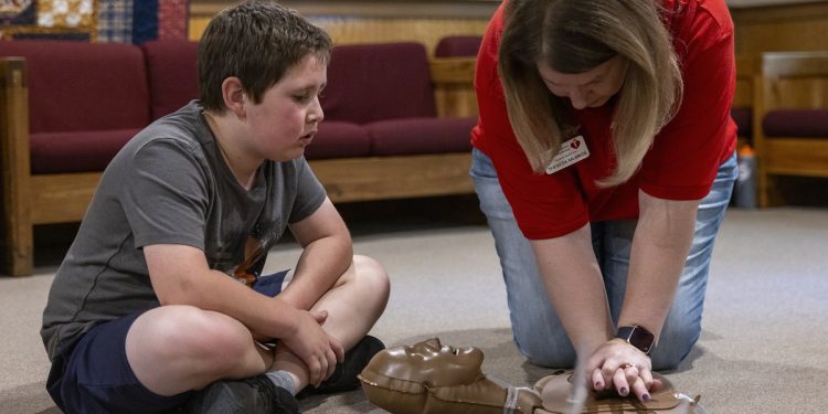 Camper Ben Wooden, left, learns about cardiopulmonary resuscitation from Theresa McBride of the American Heart Association at Camp Lionheart. Children with congenital heart disease have fun, connect with one another and learn about their conditions during the annual summer camp.