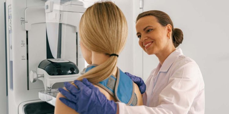 Woman doing mammogram x ray for breast cancer prevention screening at hospital