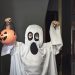 They knock on the door and when it opens, a boy dressed as a ghost appears in the foreground.  Trick or Treat!