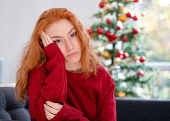 Depressed young red haired woman on christmas holiday