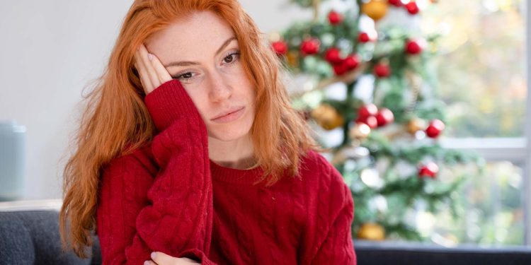 Depressed young red haired woman on christmas holiday